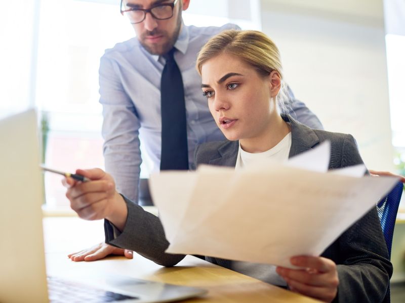 ragazza mostra a collega un report sul computer